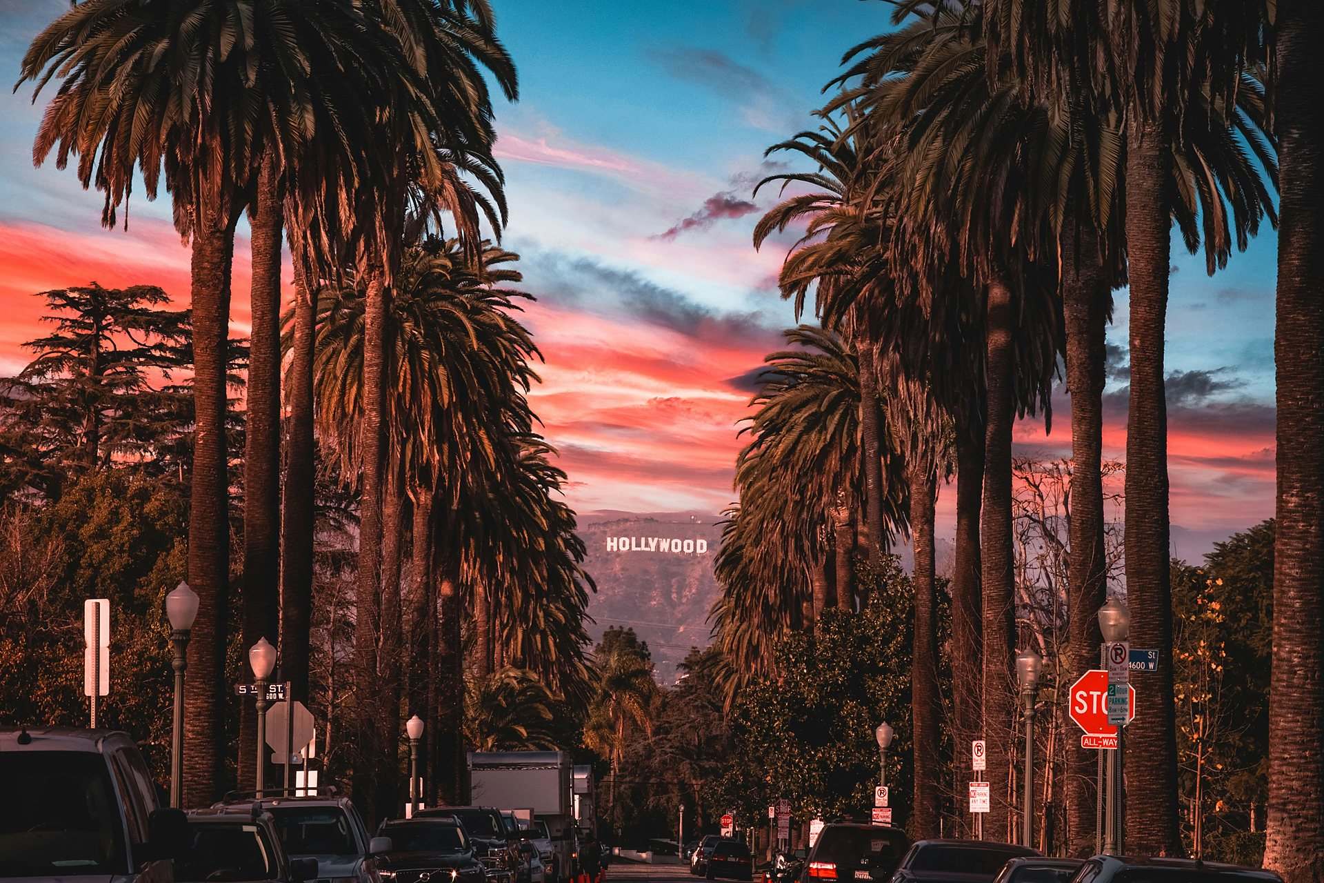 Palm-lined street with the Hollywood sign at sunset in Los Angeles